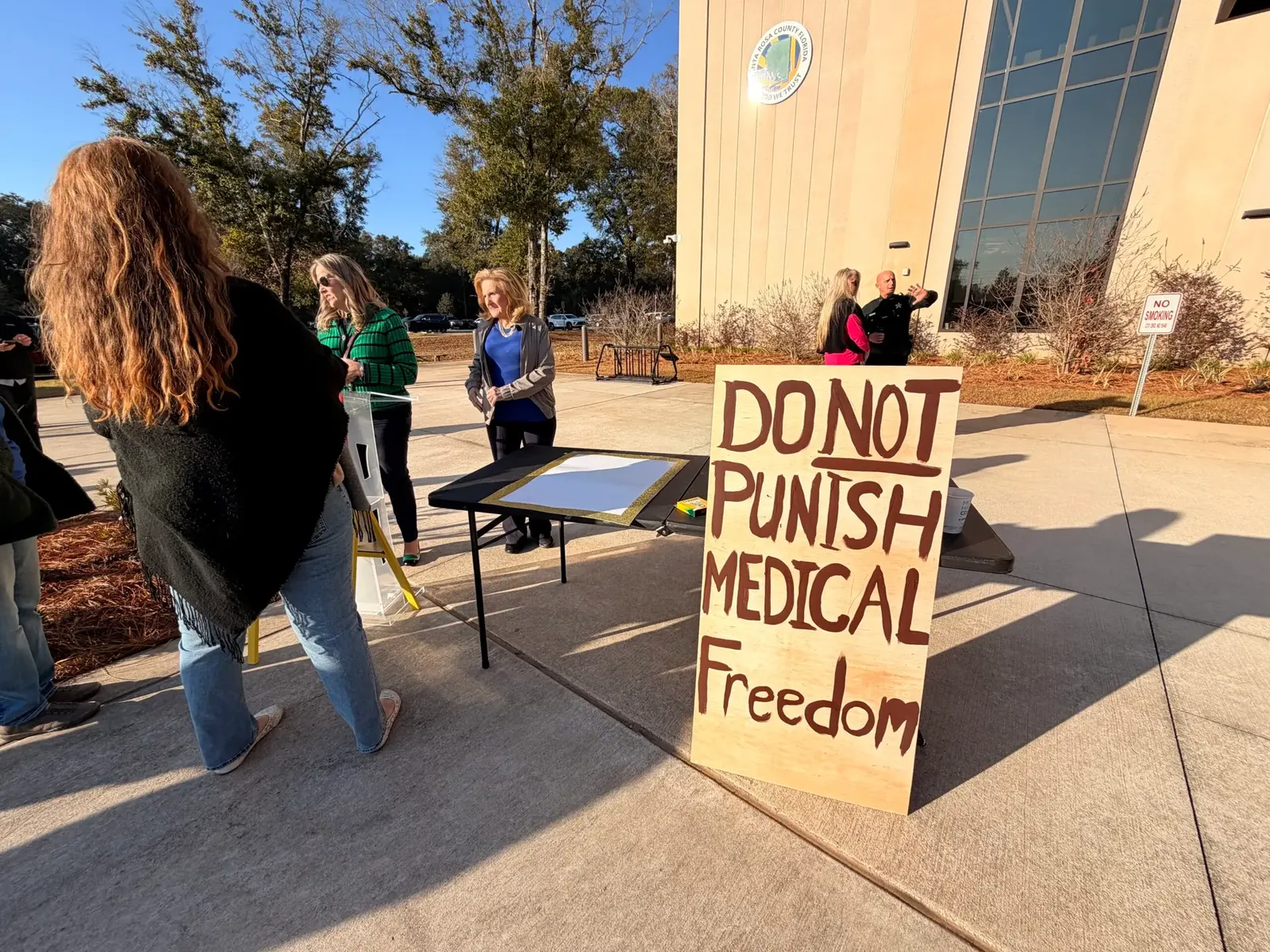 A protester holds a sign reading Do Not Punish Medical Freedom